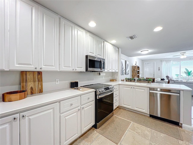 kitchen featuring sink, light tile patterned floors, white cabinetry, kitchen peninsula, and stainless steel appliances