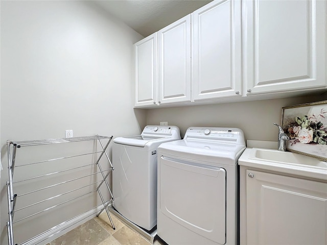 clothes washing area featuring washer and dryer, light tile patterned floors, cabinets, and sink