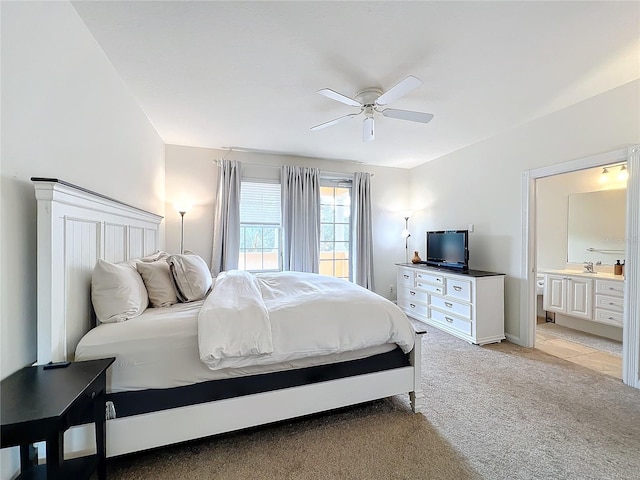 bedroom with ceiling fan, ensuite bathroom, and light colored carpet