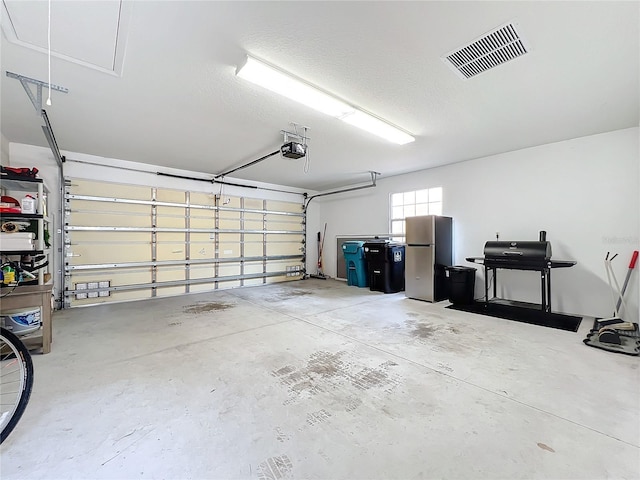 garage featuring a garage door opener and stainless steel refrigerator