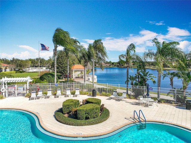 view of swimming pool featuring a water view and a patio area