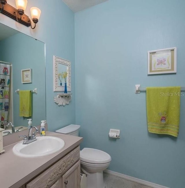 bathroom with tile patterned floors, vanity, and toilet