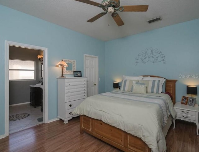 bedroom featuring connected bathroom, ceiling fan, and dark hardwood / wood-style flooring