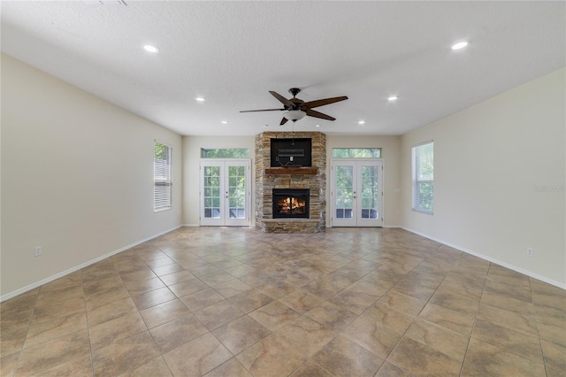 2961 Cedar Glen Pl, Oviedo, FL 32765 - unfurnished living room with french doors, a stone fireplace, a ceiling fan, and baseboards