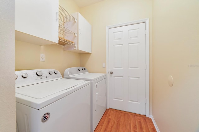 2961 Cedar Glen Pl, Oviedo, FL 32765 - clothes washing area featuring cabinet space, washing machine and clothes dryer, light wood-type flooring, and baseboards