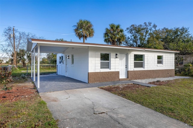 single story home featuring a carport and a front yard