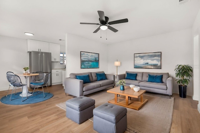 living room featuring ceiling fan and light wood-type flooring