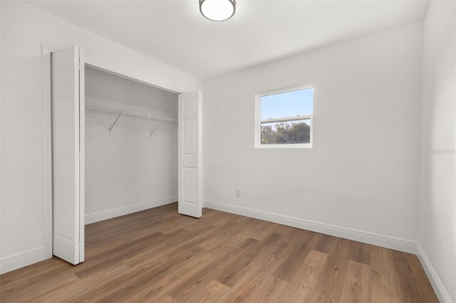 unfurnished bedroom with a closet and hardwood / wood-style floors