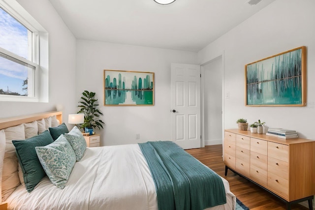 bedroom with dark hardwood / wood-style flooring