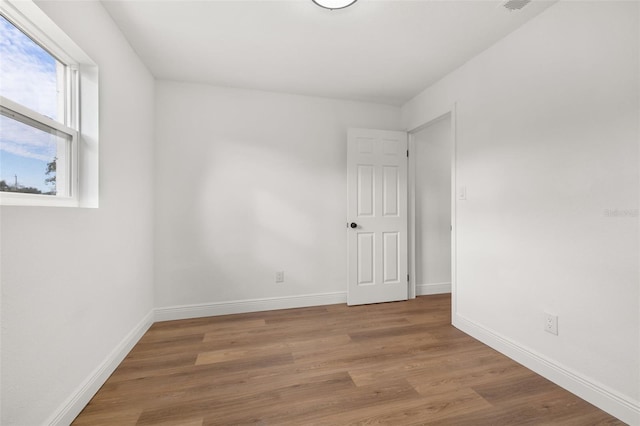 unfurnished room with hardwood / wood-style floors