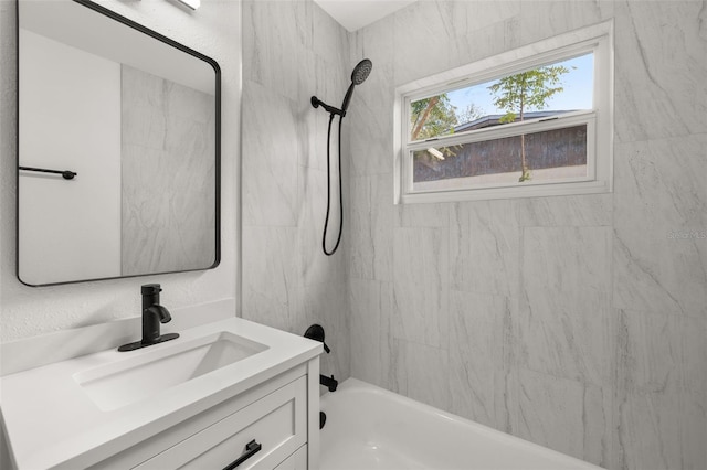 bathroom featuring tiled shower / bath combo and vanity