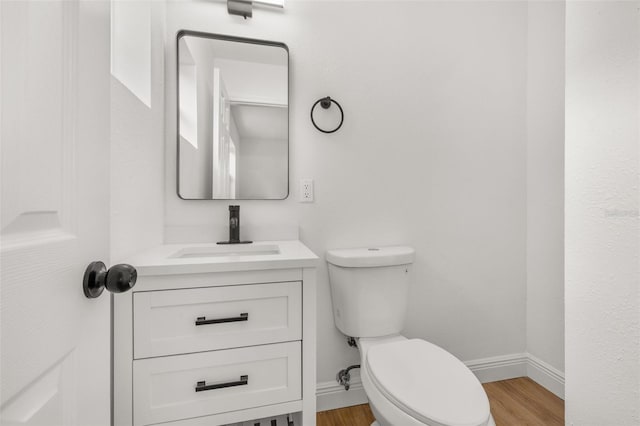 bathroom with hardwood / wood-style floors, vanity, and toilet