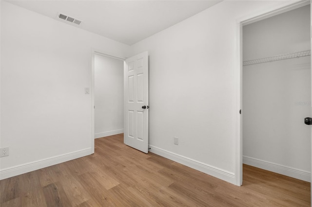 unfurnished bedroom with a closet and light hardwood / wood-style floors