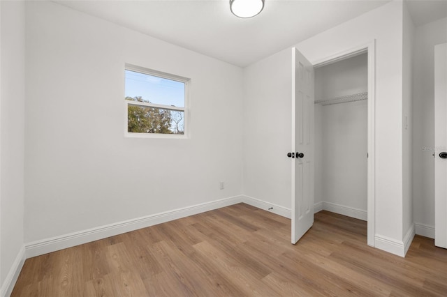 unfurnished bedroom with a closet and light wood-type flooring