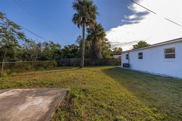 view of yard featuring central air condition unit and a patio