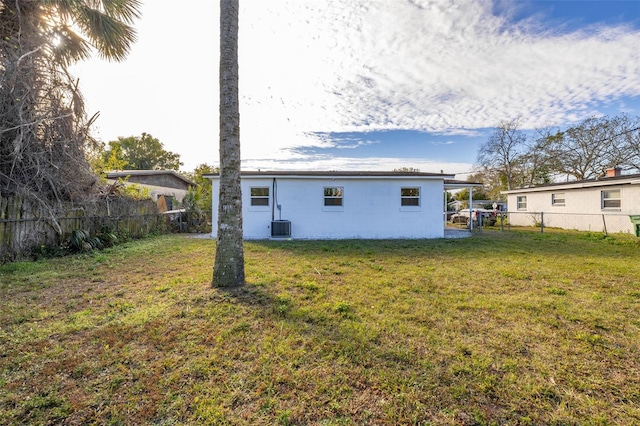 rear view of house with a yard and central AC unit