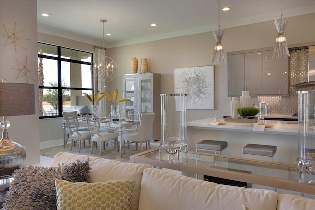 kitchen featuring decorative backsplash, decorative light fixtures, crown molding, and gray cabinetry