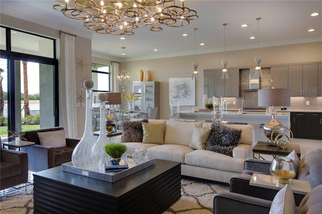 living room with crown molding and an inviting chandelier