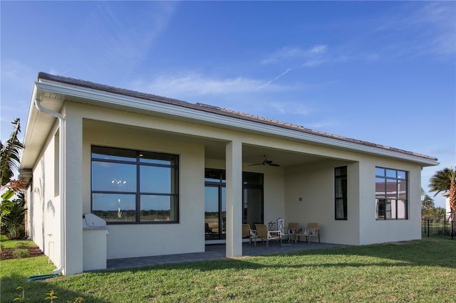 rear view of house with a lawn, ceiling fan, and a patio