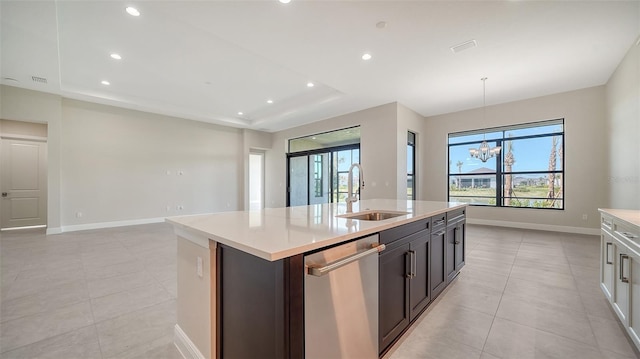 kitchen with an inviting chandelier, light tile patterned floors, an island with sink, a sink, and dishwasher