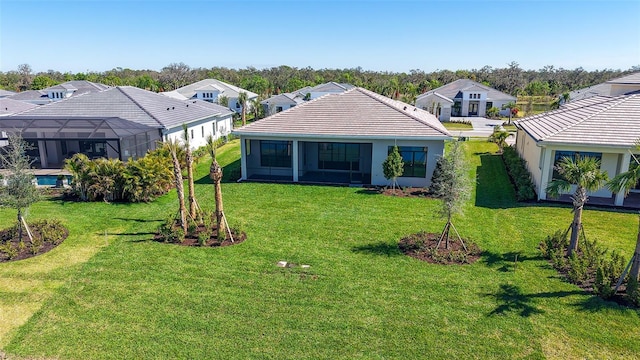view of front of property with a sunroom, a tiled roof, a residential view, and a front yard