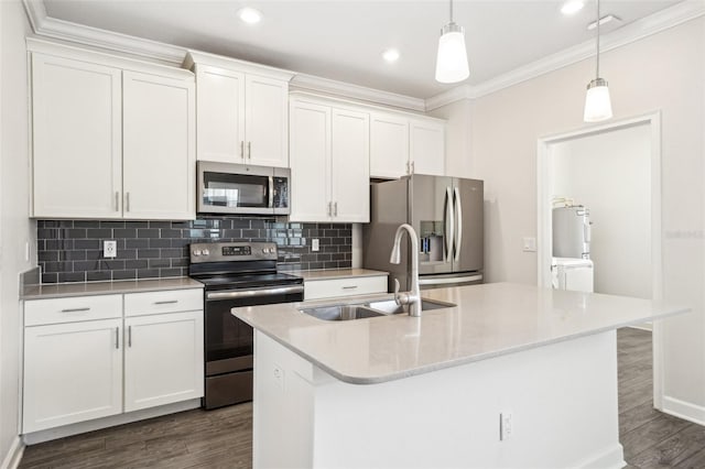 kitchen with sink, white cabinetry, hanging light fixtures, appliances with stainless steel finishes, and a kitchen island with sink