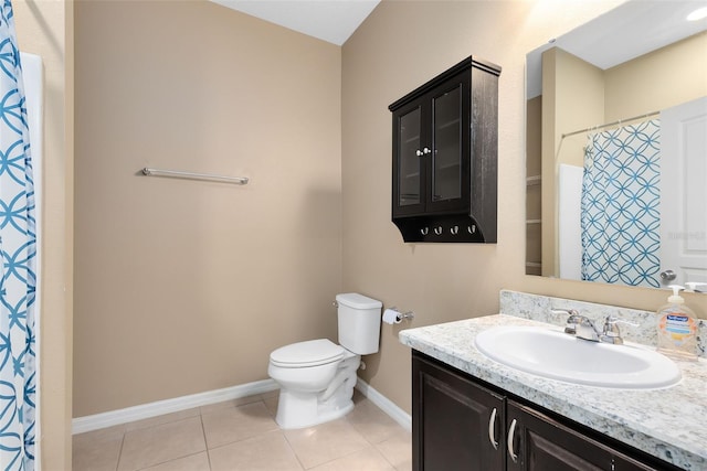 bathroom featuring tile patterned floors, vanity, toilet, and walk in shower