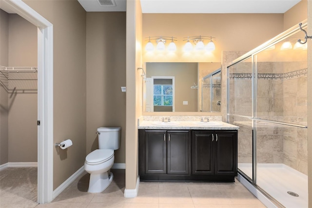 bathroom featuring tile patterned floors, a shower with door, vanity, and toilet