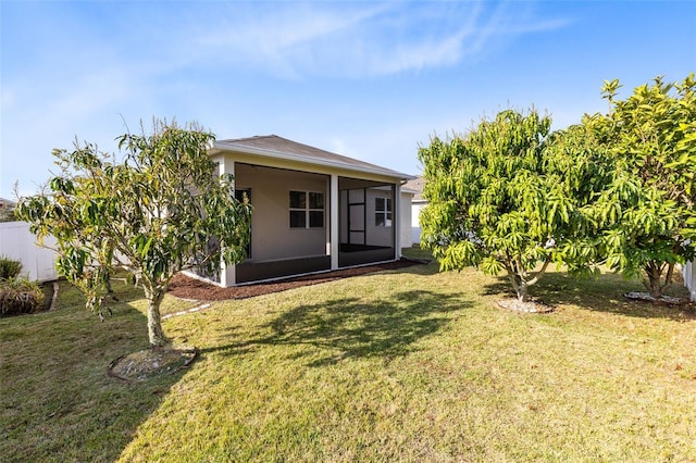 back of house with a lawn and a sunroom