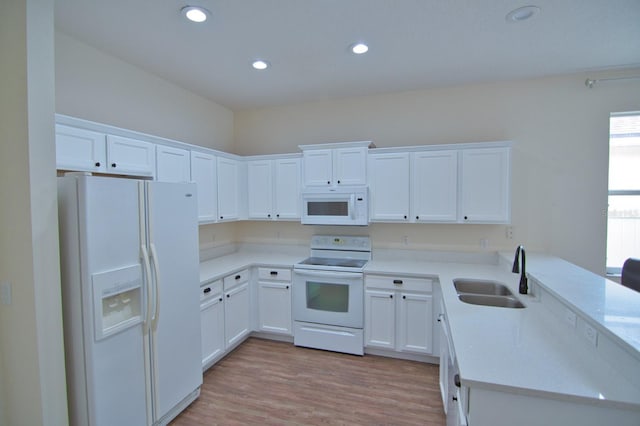 kitchen with sink, white appliances, white cabinets, and light wood-type flooring