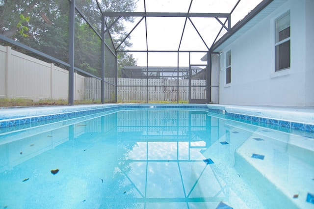 view of pool featuring glass enclosure