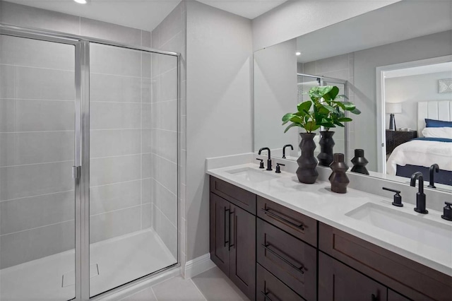 bathroom with tile patterned floors, a shower with door, and vanity