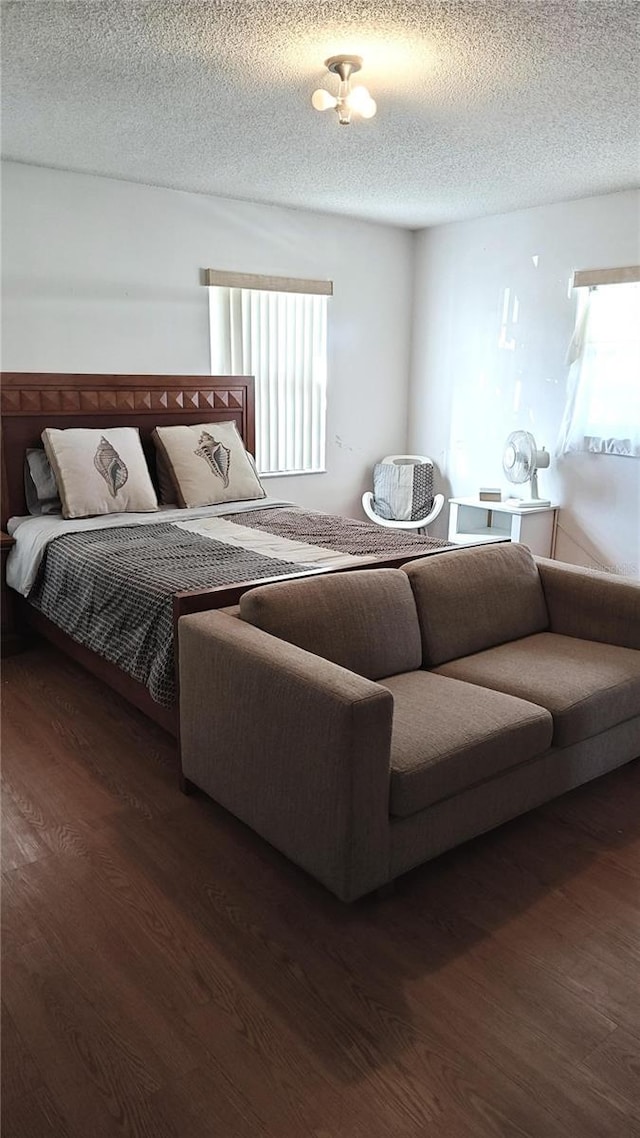 bedroom featuring dark hardwood / wood-style floors and a textured ceiling