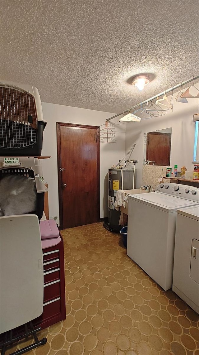 washroom featuring independent washer and dryer, a textured ceiling, and water heater