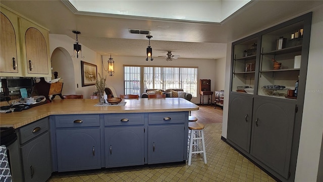 kitchen featuring hanging light fixtures, ceiling fan, blue cabinetry, black / electric stove, and kitchen peninsula