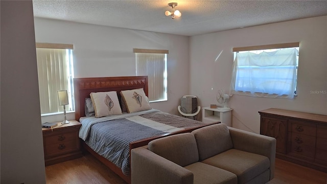 bedroom with wood-type flooring and a textured ceiling