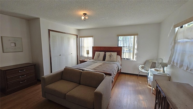 bedroom with hardwood / wood-style floors, a textured ceiling, and a closet