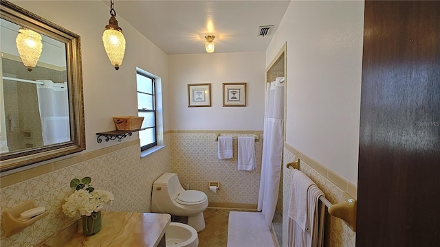 bathroom featuring a bidet, a shower with shower curtain, tile walls, and toilet