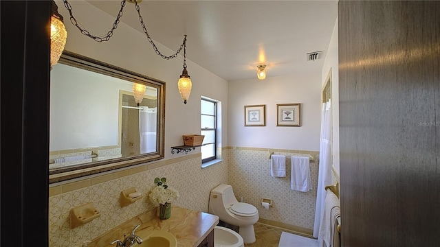 bathroom featuring a shower with curtain, vanity, a bidet, tile walls, and toilet