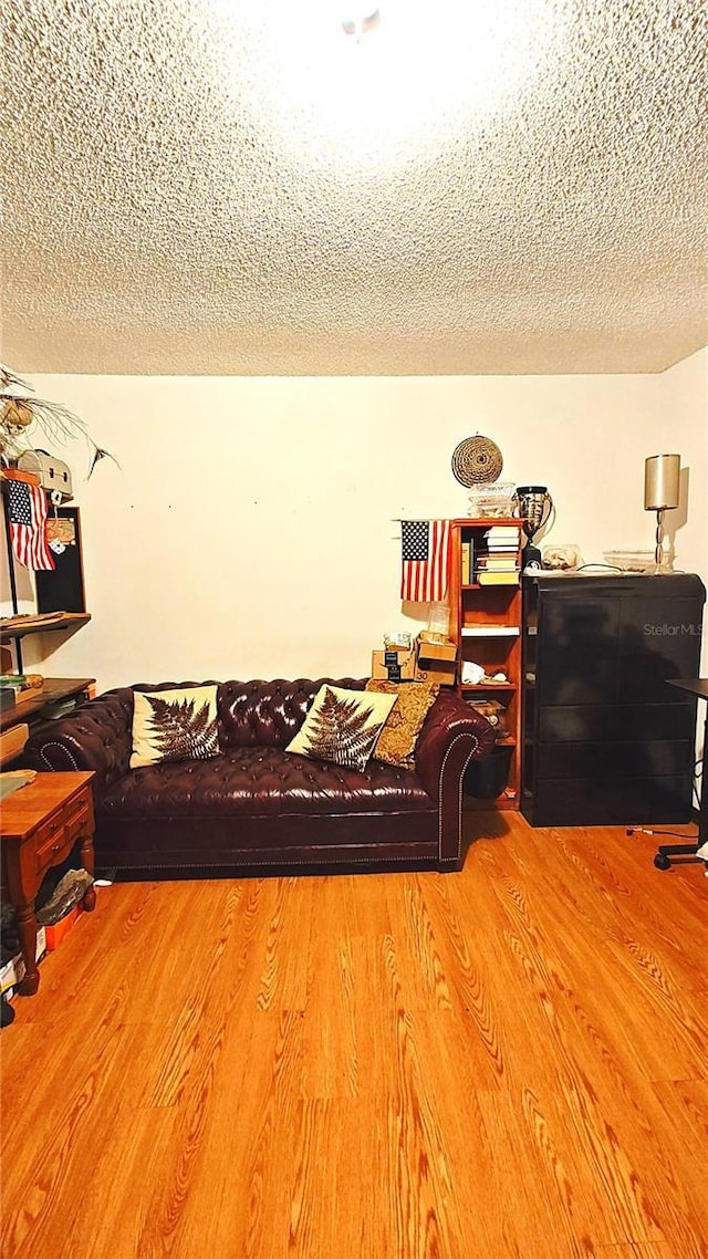 living room with hardwood / wood-style floors and a textured ceiling