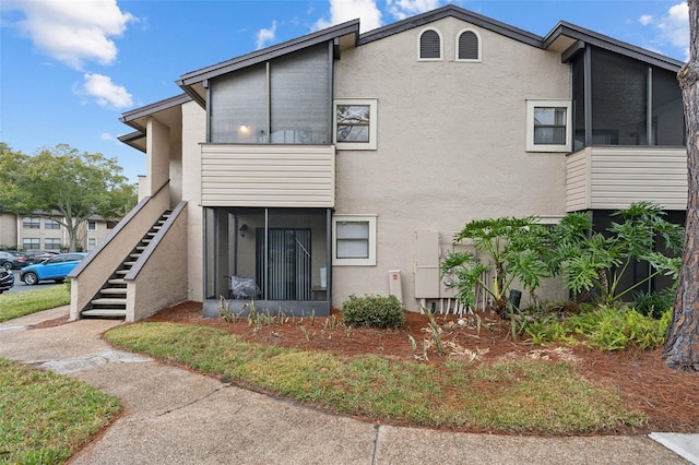 rear view of property featuring a sunroom