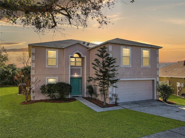 view of front of house featuring a yard and a garage