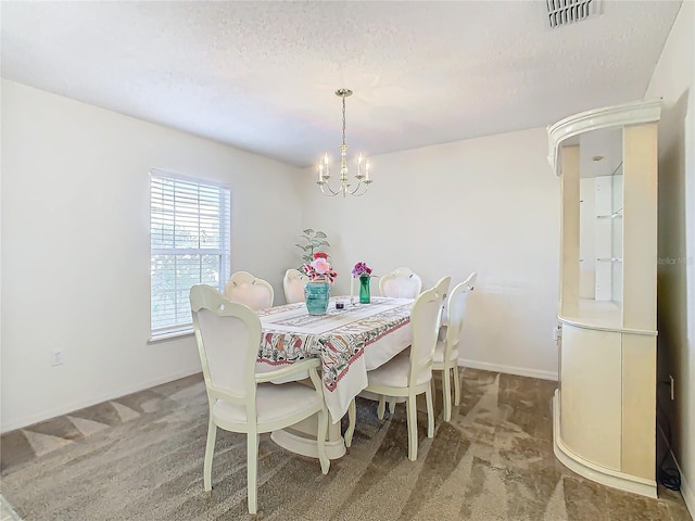 dining area with carpet, a textured ceiling, and an inviting chandelier