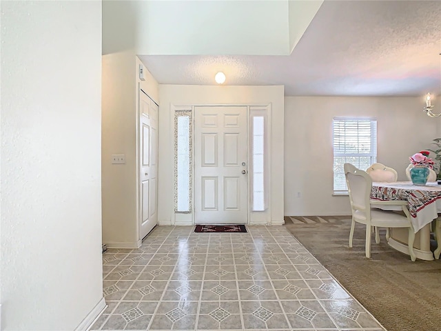 foyer with carpet and a textured ceiling