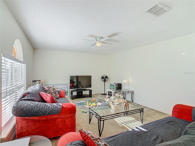 carpeted living room with a textured ceiling and ceiling fan