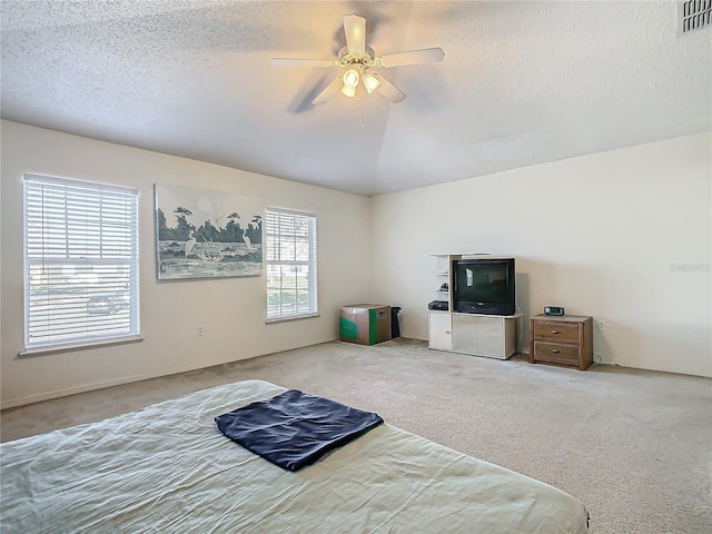 carpeted bedroom with multiple windows, a textured ceiling, and ceiling fan