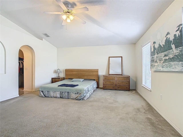 bedroom with ceiling fan, light carpet, and vaulted ceiling