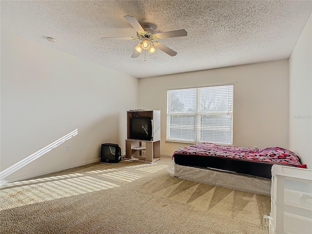 carpeted bedroom featuring ceiling fan and a textured ceiling