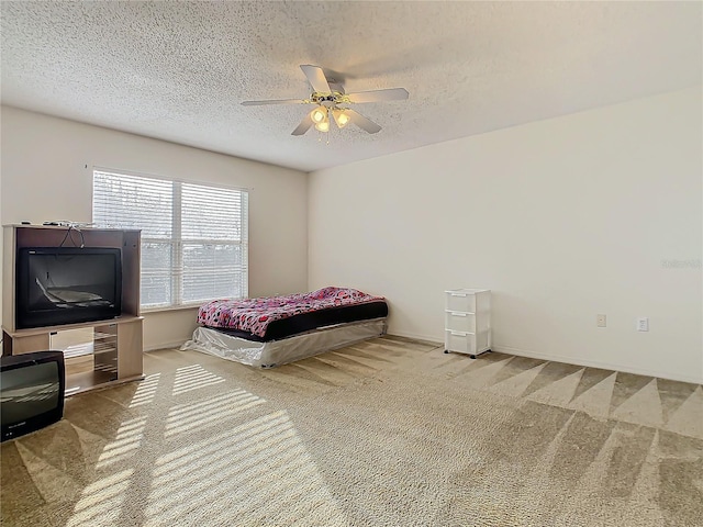 carpeted bedroom with ceiling fan and a textured ceiling