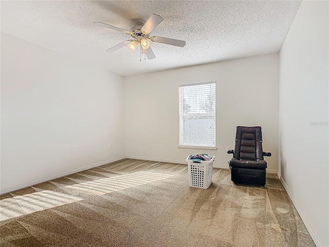 unfurnished room with carpet, ceiling fan, and a textured ceiling